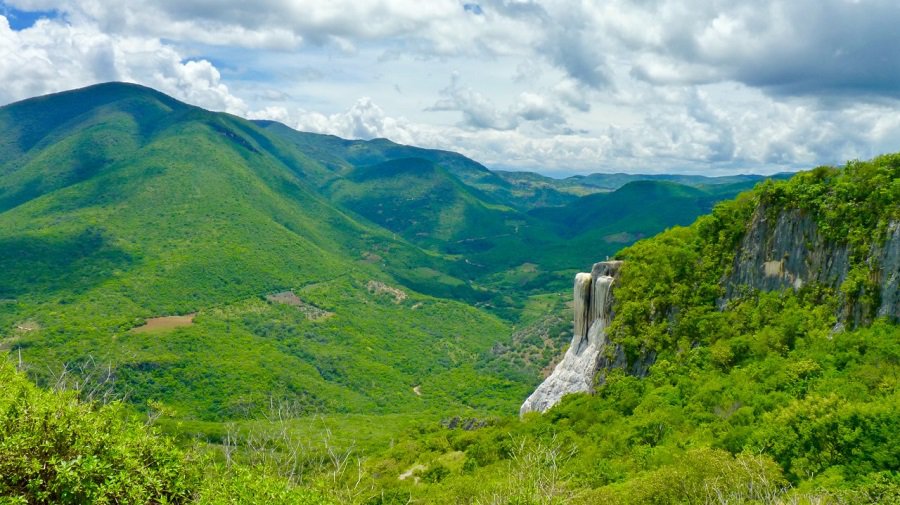 Hierve el Aqua - 'the water boils' - is named for the places where rock formations look like waterfalls, seen here in a lush, green valley.