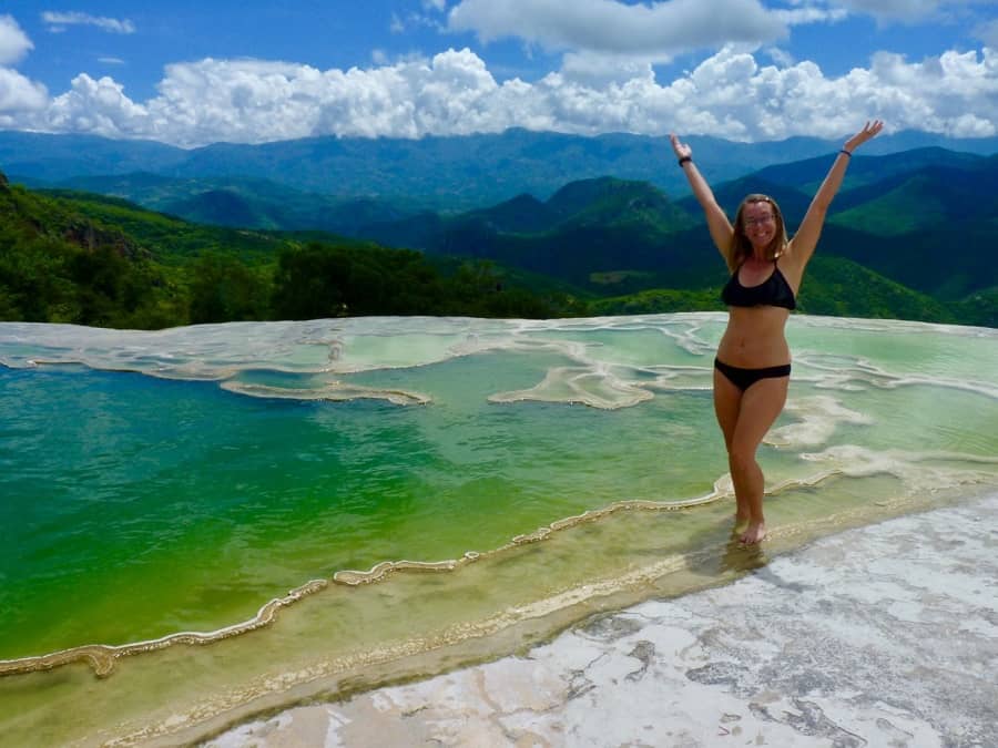 Infinity pools overlook a valley to mountains with pretty clouds at Hierve el Agua in Oaxaca.