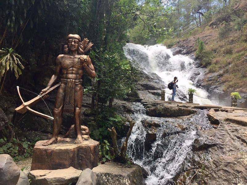 a statue of a native person at the dalat waterfall