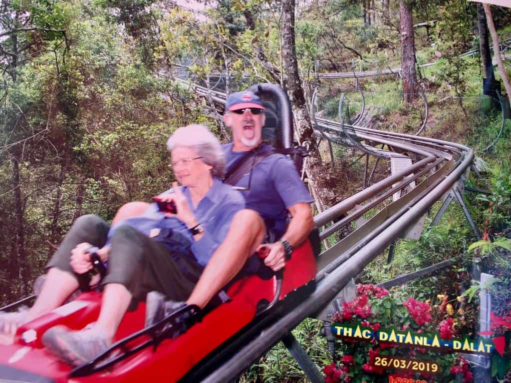 a man and his mom smile as they zoom by on the dalat roller coaster