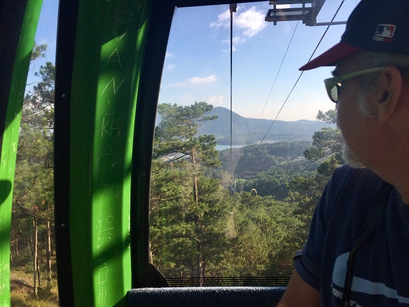 a man looks out of the dalat cable car