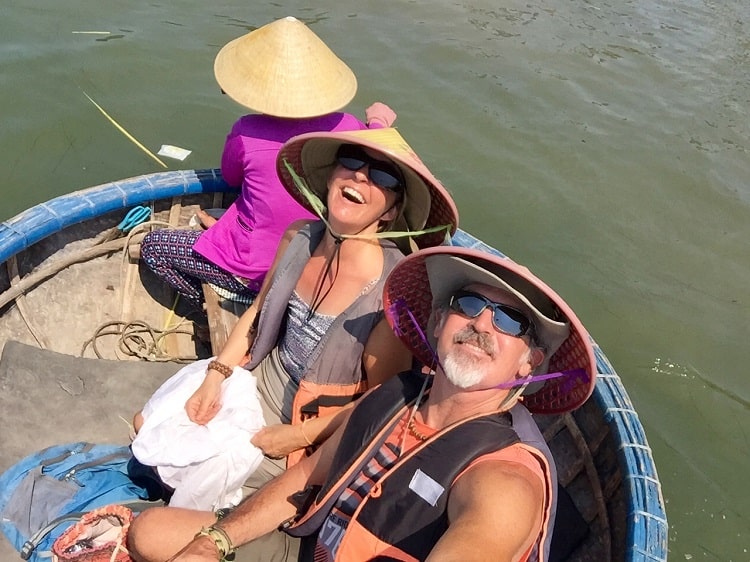 three people in Vietnamese style hats in a so-called 'basket boat'