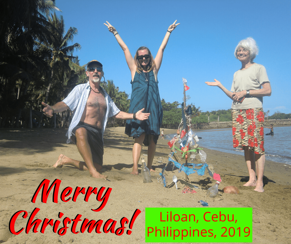 me, tedly, mom diane stand around the trashy christmas tree on the beach with the words "merry christmas, liloan, cebu, 2019"