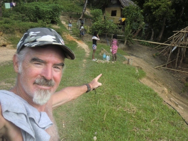 Theo smiles and points to a working spigot in the successful Ati water pump project.