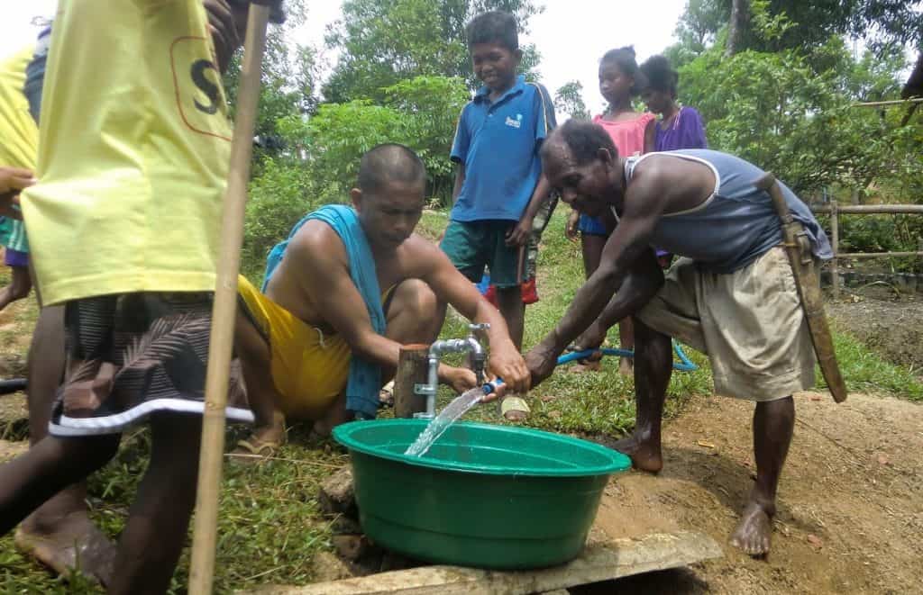 Ati men fill tub with water from the new pump installed by Earth Vagabonds and overseas donors in Malay, Aklan, Philippines.