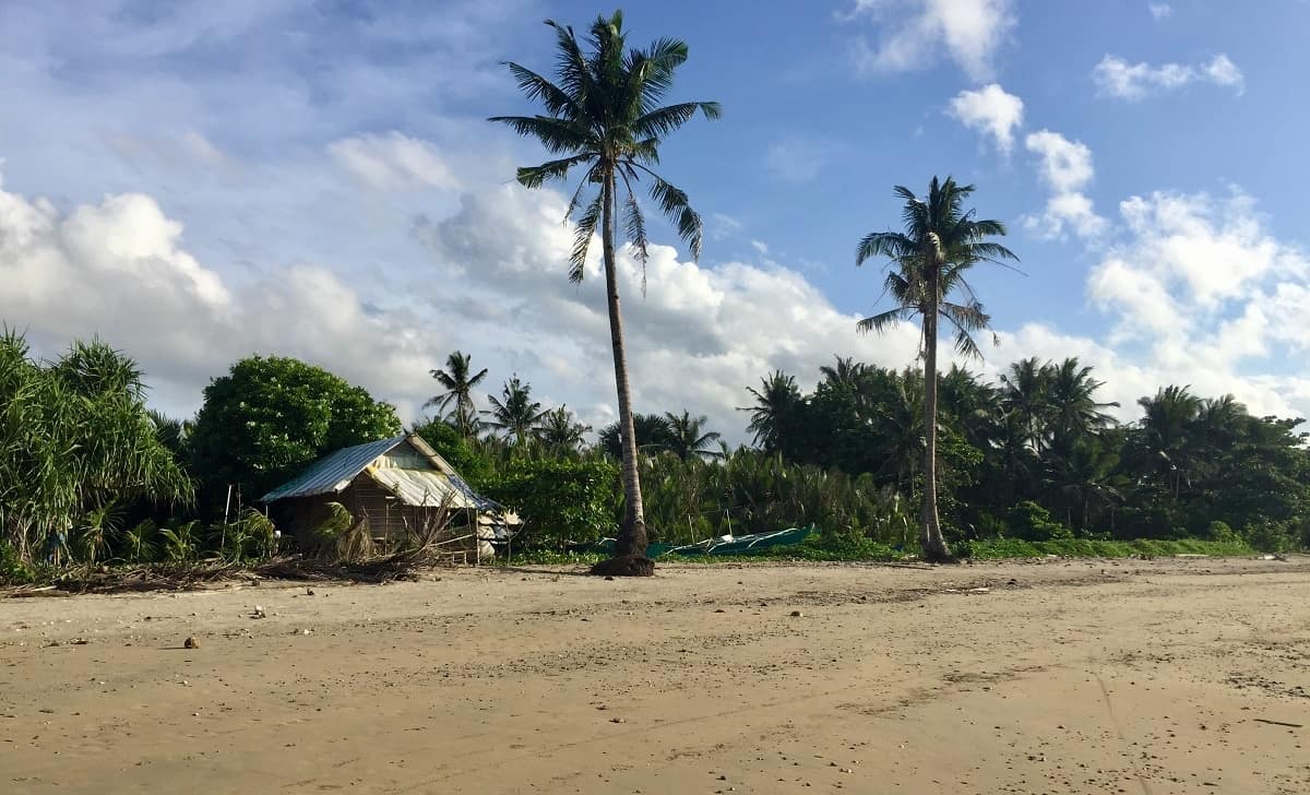 A modest nipa hut on a mainland Malay beach in the Philippines.