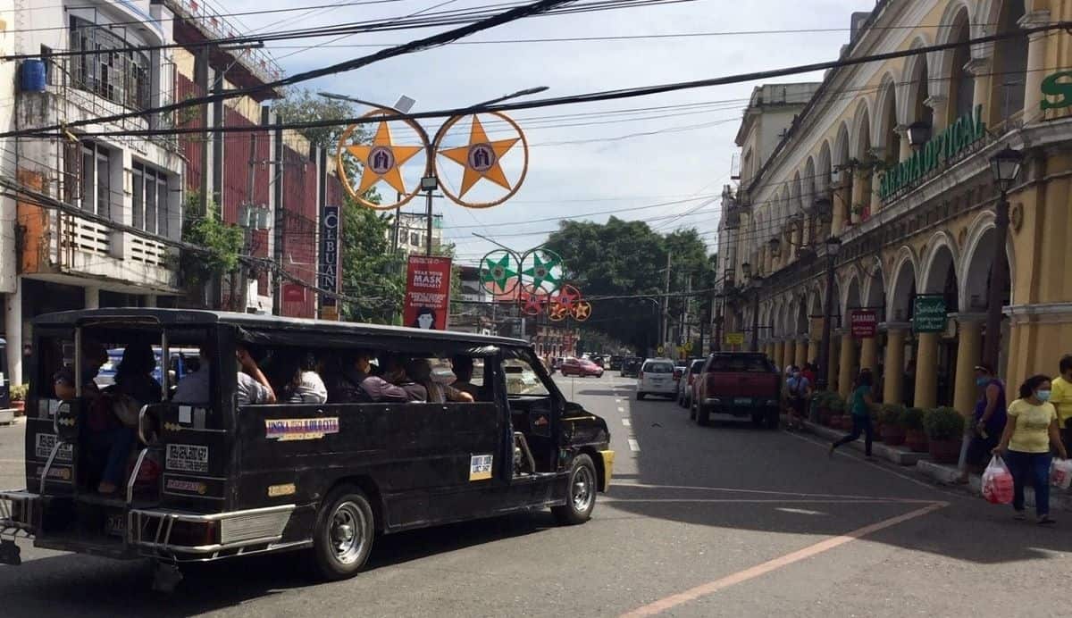 Iloilo City proper with a jeepney full of passengers.