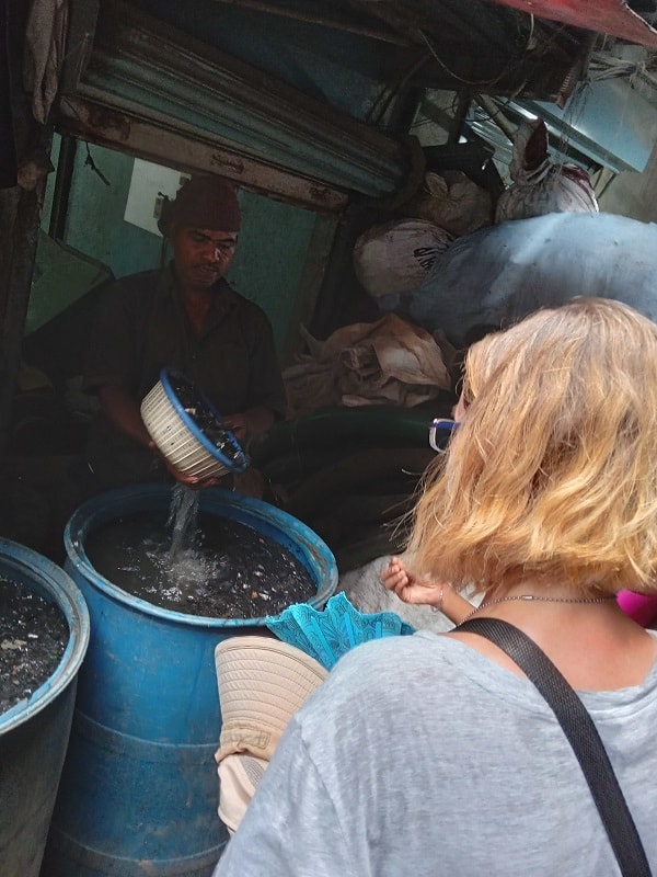 Ellen watches a man wash plastic bits with chemicals in the Dharavi slum in Mumbai.