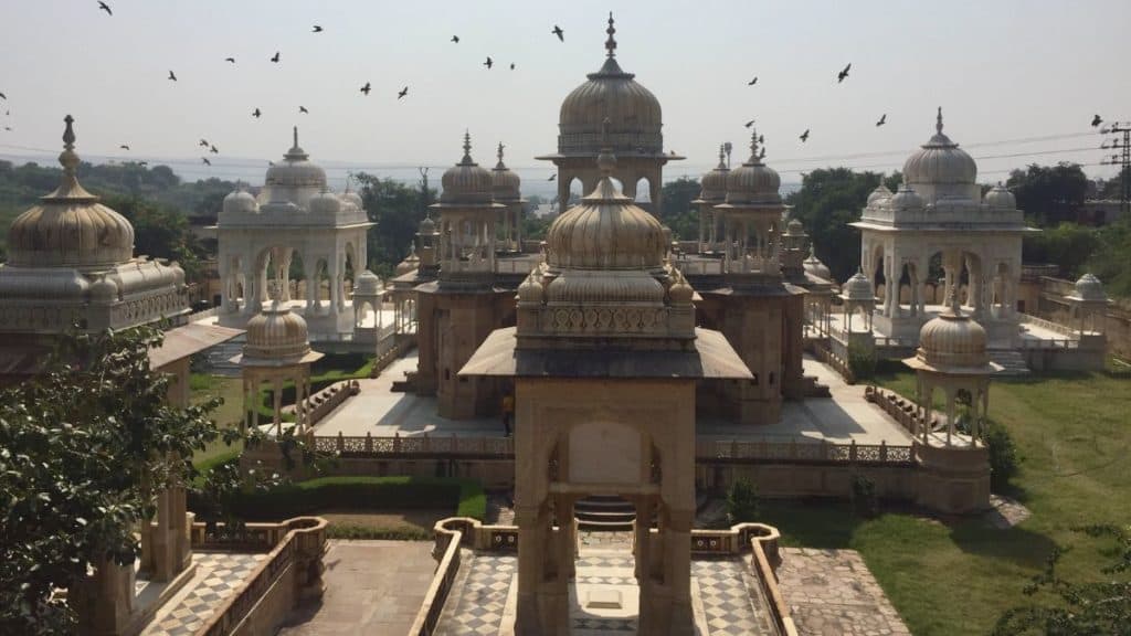 kings' crematorium and ornate honor monuments in jaipur with birds flying overhead