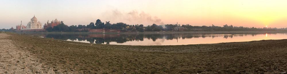 Pano shot: left, Taj Mahal; center, crematory smoke; right, sunset over the Yamuna River in Agra, India.