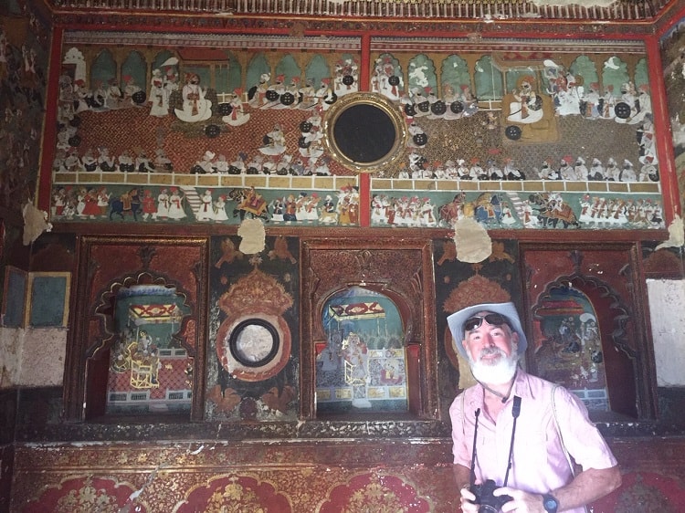Theo smiles by gold paintings in 17th century Garh Palace.