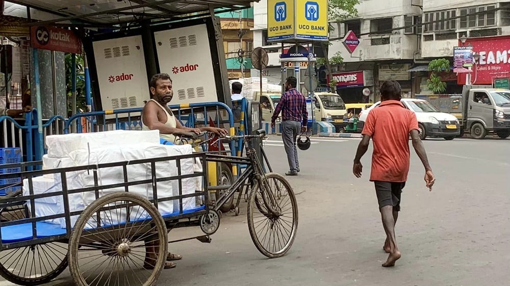 barefoot man on street in kolkata, india