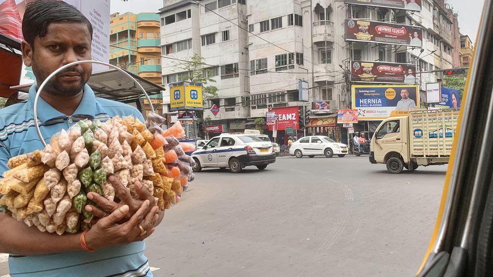 street vendor at a taxicab window in kolkata, india