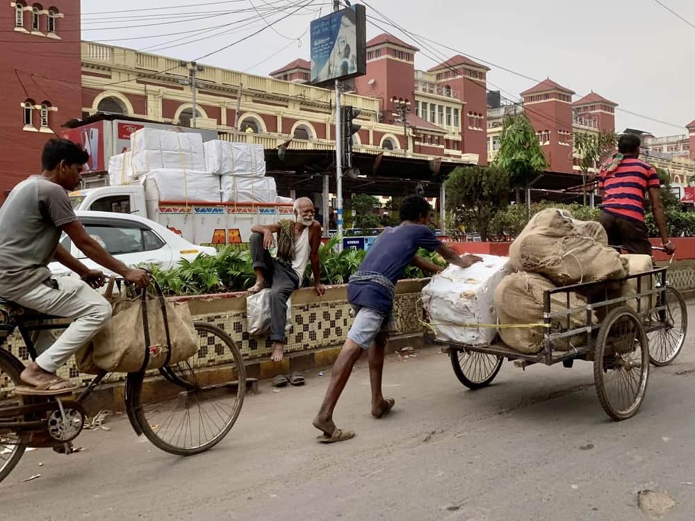 man pushing heavy cart in kolkata, india